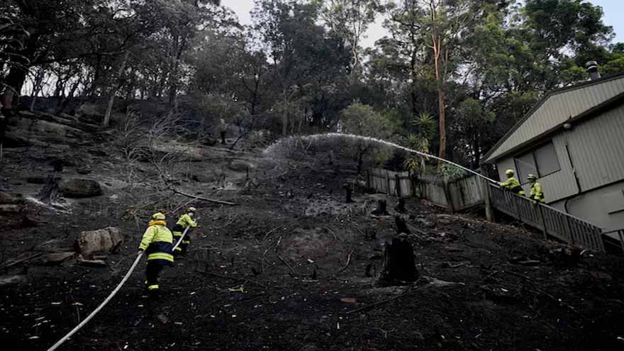 Australian bushfires raze homes in two states; firefighter dies